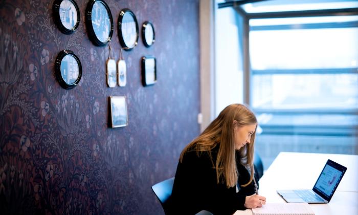 En jente sitter og jobber med pc på et av kontorene som kan lånes i 4. etasje, Kiellandsenteret.
