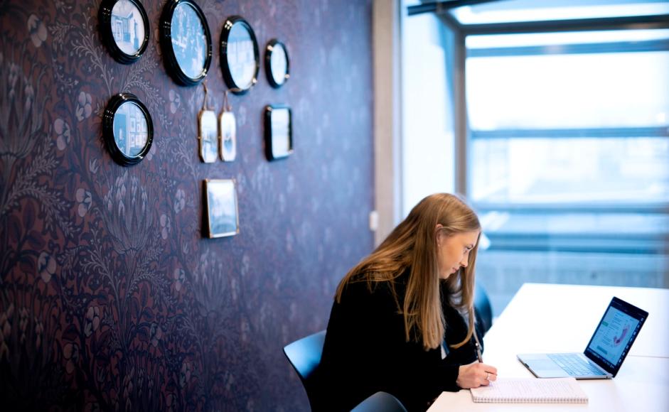 En jente sitter og jobber med pc på et av kontorene som kan lånes i 4. etasje, Kiellandsenteret.