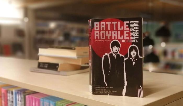 Battle royale av Koushun Takami stående på bokhylle i bibliotek
