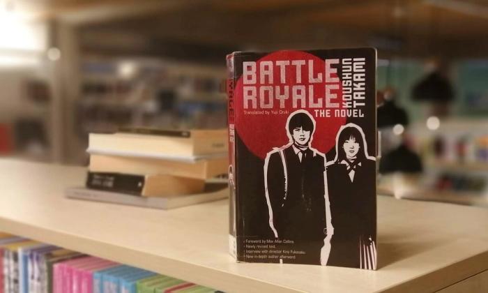 Battle royale av Koushun Takami stående på bokhylle i bibliotek