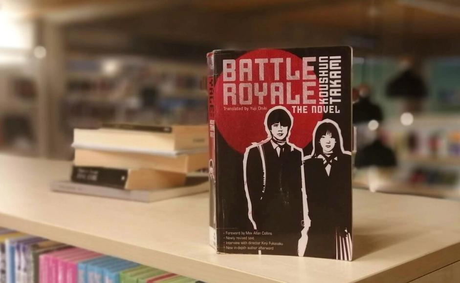 Battle royale av Koushun Takami stående på bokhylle i bibliotek