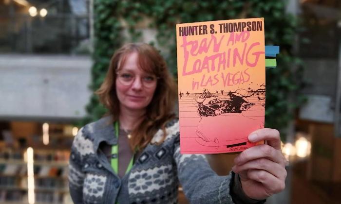 Lotte Løkeland Hovda holder boka Frykt og avsky i Las Vegas mot kamera