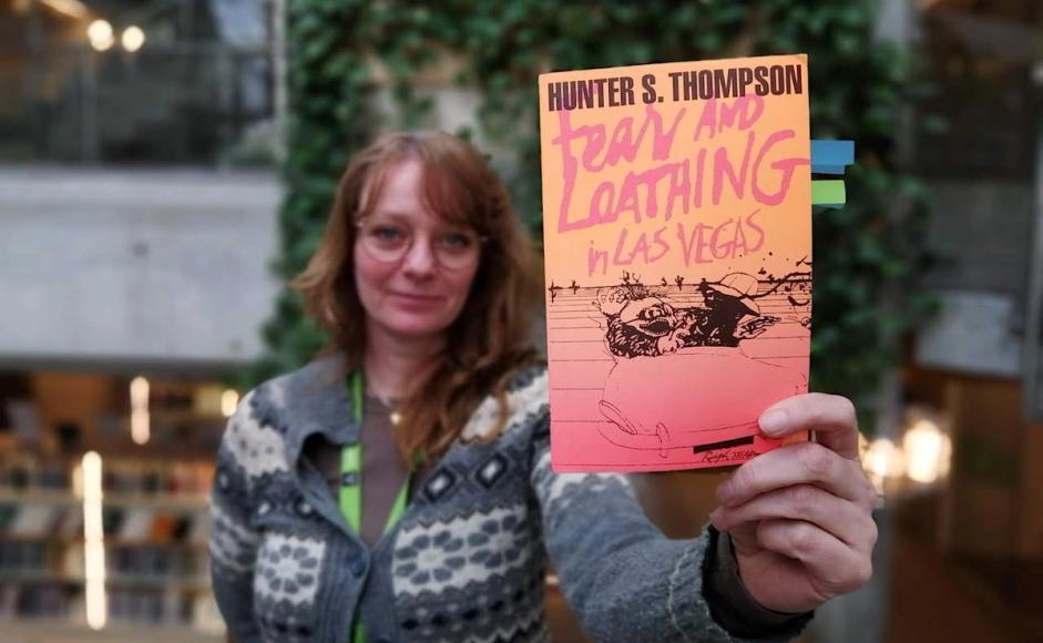 Lotte Løkeland Hovda holder boka Frykt og avsky i Las Vegas mot kamera