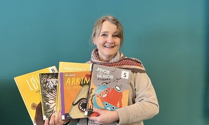 Bibliotekar Ingrid Bie Helgesen viser frem barnebøker.