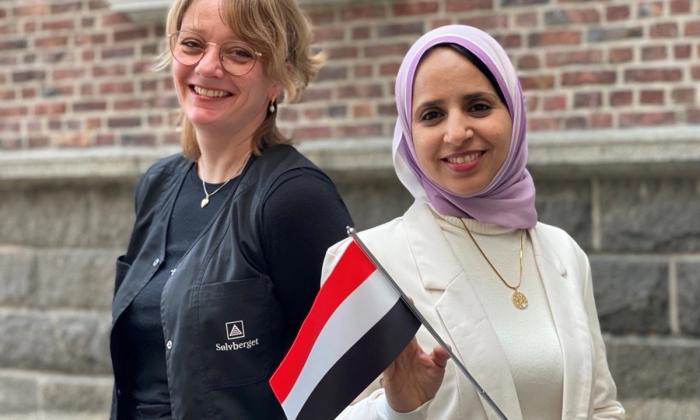 Fribykoordinator Lotte Løkeland Hovda og fribykunstner Hayat Al-Sharif på Sølvberget med et jemenittisk flagg.