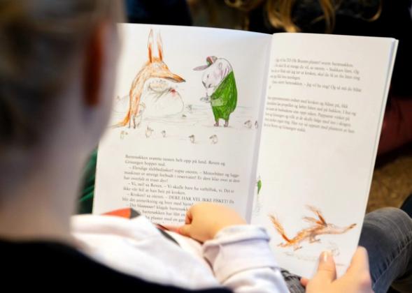 En voksen leser boken "Vaffelfisken" for et barn
