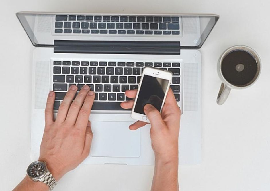 Hender på tastatur og mobiltelefon
