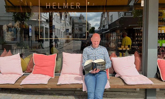 Åsmund Ådnøy leser Torgrim Eggens bok Bredt fokus utenfor Helmer te og kaffe i Stavanger.jpg