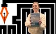 Marianne Hovdan holder boka Eg får aldri sjå verda igjen med designelement fra Ytringsfrihetsbyen Stavanger som bakgrunn