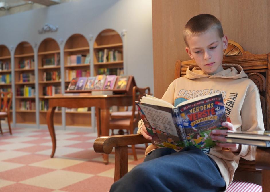 Gutt leser i biblioteket