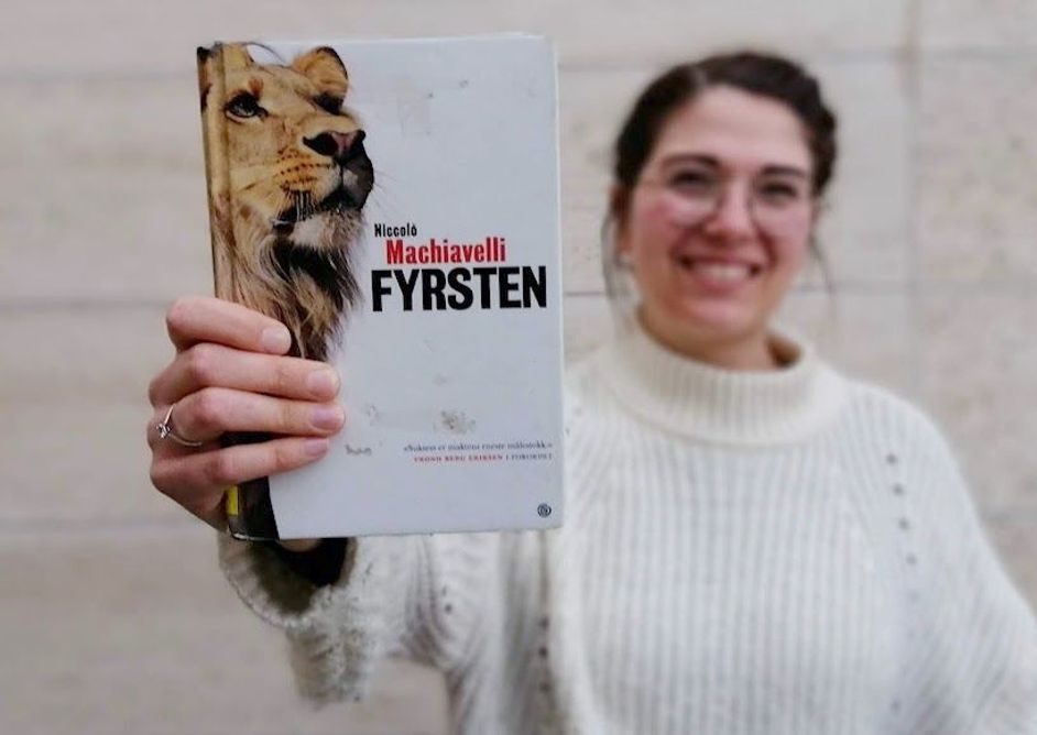 Sofie Birgitte Andersen holder boka Fyrsten av Niccolo Machiavelli mot kamera. Foto.