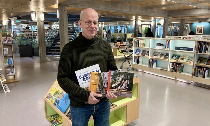 Foto av forfatter Bjørn Arild Ersland med bøker han har skrevet.