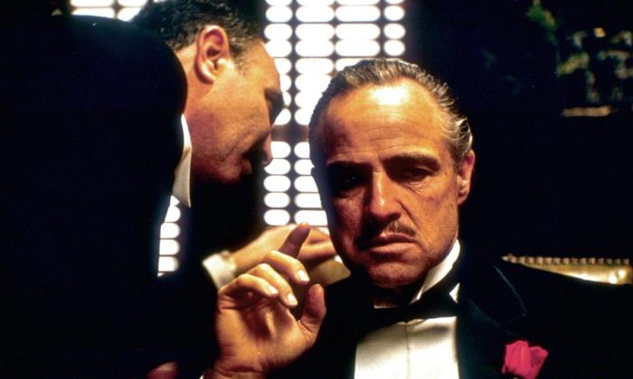 En mann hvisker i øret til en annen. Foto hentet fra filmen The Godfather fra 1972.