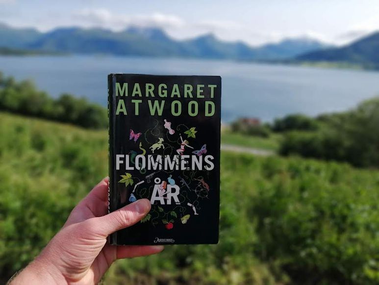 Flommens år av Margaret Atwood holdt foran en fjord