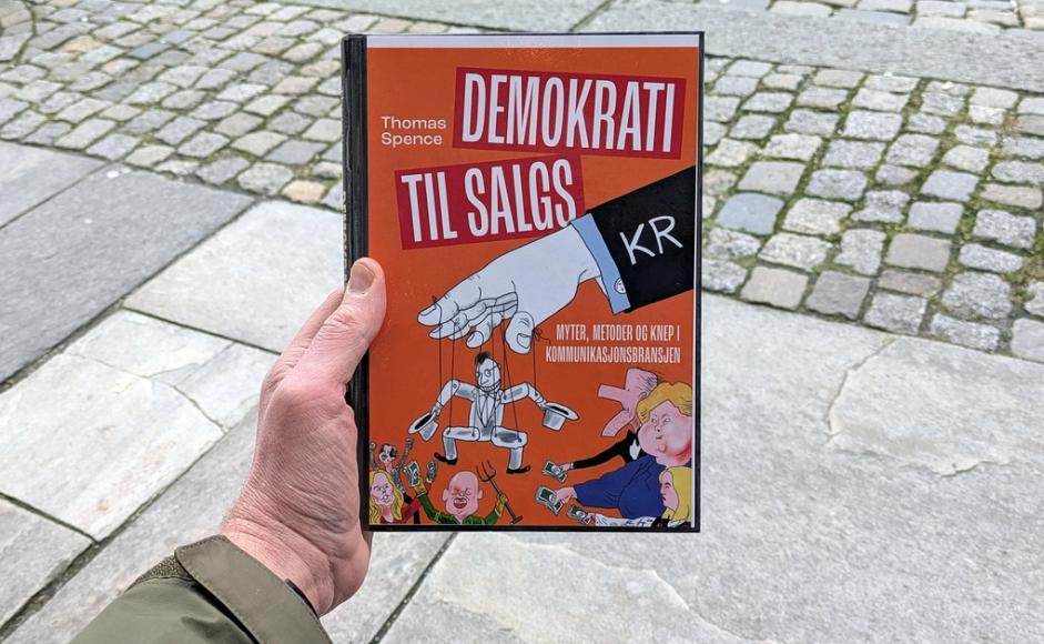 Boka Demokrati til salgs holdt foran et gateløp