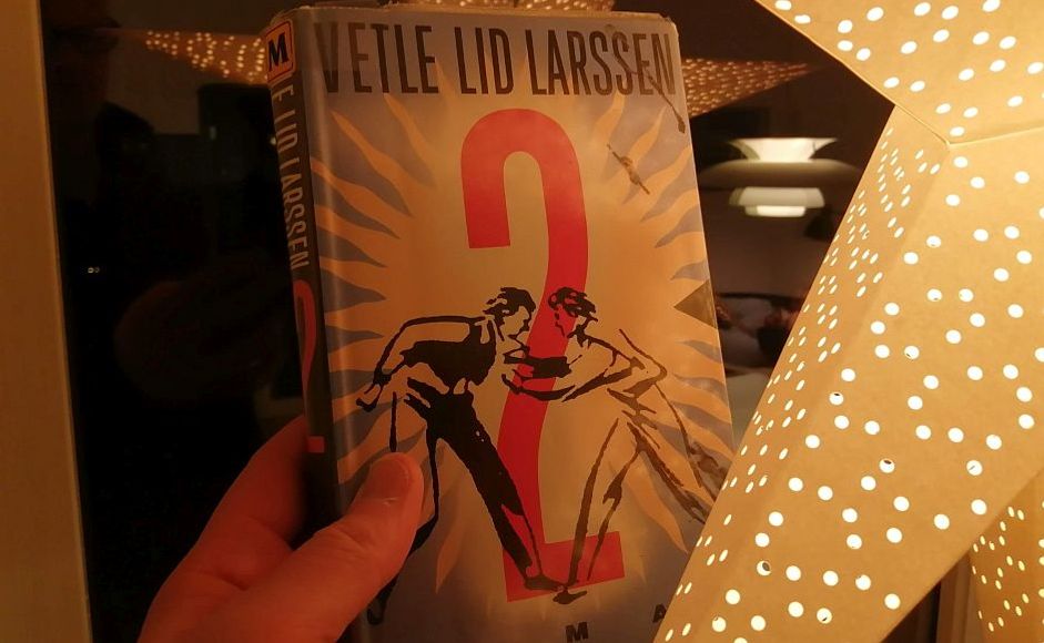 Boka 2 av Vetle Lid Larssen holdt foran en julestjerne